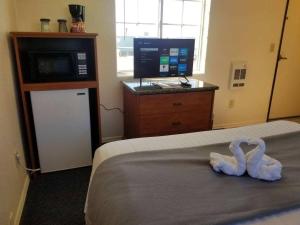 two swans sitting on a bed in a hotel room at 012C Affordable Retreat near South Rim Sleeps 2 in Valle +5 photos
