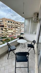 una camera con sedie e un tavolo sul balcone di Onhezmi Apartment a Sarandë