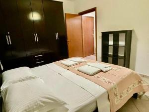 una camera da letto con un grande letto con armadi marroni di Onhezmi Apartment a Sarandë