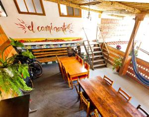un restaurant avec des tables en bois, des chaises et des escaliers dans l'établissement Hostal El Caminante, à El Cocuy