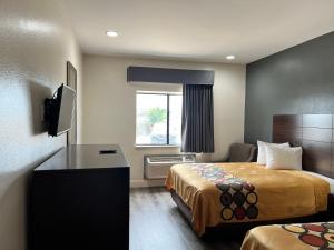 ein kleines Hotelzimmer mit 2 Betten und einem Schreibtisch in der Unterkunft Econo Lodge Beaumont I-10 South in Beaumont