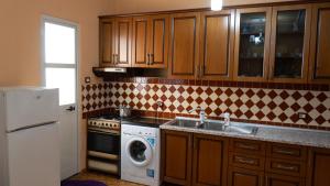 een keuken met een wastafel en een wasmachine bij Villa Osmani in Durrës