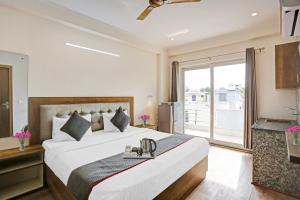 a bedroom with a large bed and a large window at Hotel Luxury Villa Near Delhi IGI Airport in New Delhi