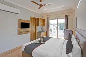Schlafzimmer mit einem Bett und einem Deckenventilator in der Unterkunft Hotel Luxury Villa Near Delhi IGI Airport in Neu-Delhi