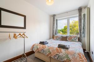 sypialnia z łóżkiem i oknem w obiekcie Modern 2 bedroom apartment in Mitcham, London w mieście Mitcham