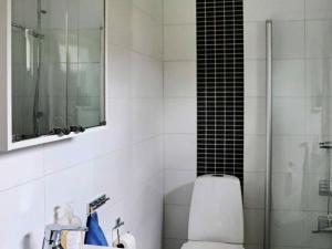 a bathroom with a shower and a toilet and a mirror at 5 star holiday home in STENINGE in Steninge +23 photos
