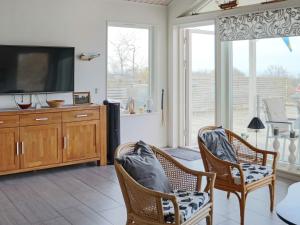 a living room with two chairs and a flat screen tv at 5 star holiday home in STENINGE in Steninge
