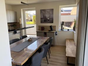 a kitchen and dining room with a table and chairs at Holiday home Ankerherz in Butjadingen