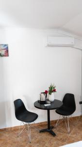 a black table and two chairs in a room at Villa Osmani in Durrës