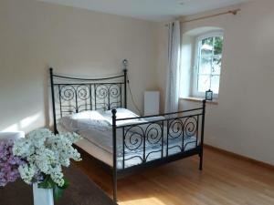 una camera da letto con un letto nero e un vaso di fiori di Zonnehof in het Geiseltal 