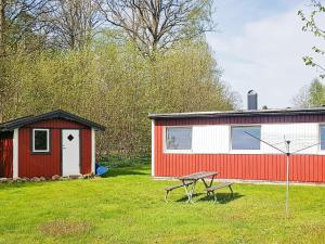 a red and white shed and a picnic table in a yard at 4 star holiday home in Olofström-By Traum in Olofström