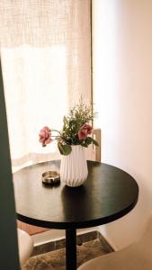 un vaso con fiori seduto su un tavolo di Villa Osmani a Durrës
