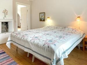um quarto com uma cama num quarto com uma lareira em Holiday home HÖGSBY II em Högsby