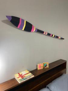 un long bâton suspendu au mur au-dessus d'une étagère dans l'établissement Casa Climatizada-2km centro Histórico, à Parati