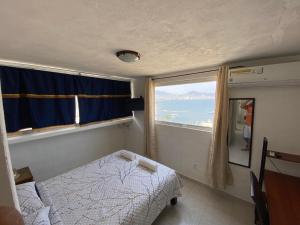 a small bedroom with a bed and a window at Sierra 1 in Acapulco