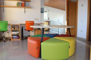 una mesa con taburetes coloridos en una habitación en el turó en Sant Boi de Lluçanès