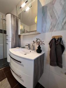 a white bathroom with a sink and a mirror at Ferienwohnung Maasch in Vierraden +19 photos
