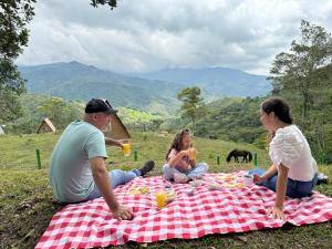 a group of people sitting on a picnic blanket at Eco hotel Birdland en Buga Valle in La Habana