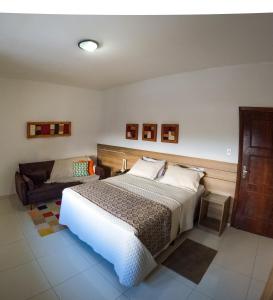 - une chambre avec un lit et un canapé dans l'établissement Pousada da Seresta, à Diamantina