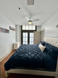 a bedroom with a blue bed with a ceiling fan at Heart of the French Quarters in New Orleans