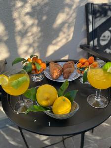 Denis Apartment في زدريلاك: طاولة مع أطباق من الفاكهة وأكواب من عصير البرتقال