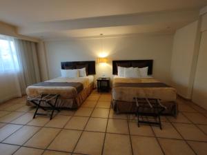 Bella Luxury Suite in Coronado في بلايا كورونادو: غرفة فندقية بسريرين و كرسيين