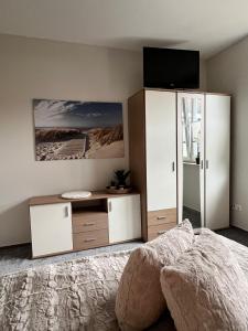 a bedroom with a bed and a tv and a cabinet at Ferienwohnung Maasch in Vierraden