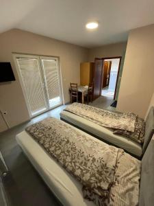 une chambre avec deux lits et une salle à manger dans l'établissement Pansion Lapam, à Visoko
