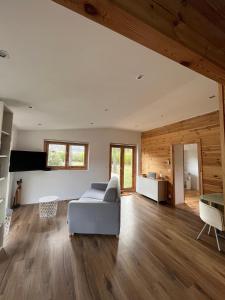 ein Wohnzimmer mit einem weißen Sofa und Holzwänden in der Unterkunft Chalet au calme avec piscine et grand jardin in Plan dʼAups