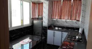 a kitchen with a stove and a sink in it at Appartement à côté de la plage in Tangier