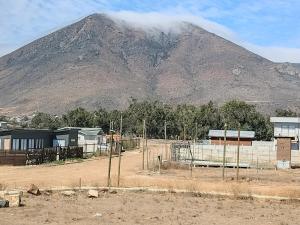 une montagne à l'arrière-plan d'une ville avec une clôture dans l'établissement Twin Brothers Pichidangui, à Pichidangui