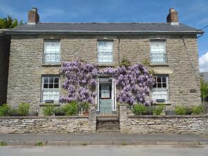 a house with wisteria on the front of it at The Harbour in Evenjobb