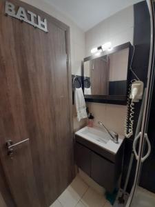 a bathroom with a wooden door and a sink at Isaias house in Rhodes Town +7 photos