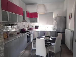 a kitchen with a table and white chairs and red cabinets at Isaias house in Rhodes Town