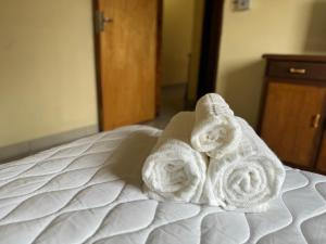 a pair of towels sitting on top of a bed at Habitaciones a minutos del centro de Asunción con quincho y piscina in Asuncion