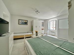 - une chambre avec un lit, un canapé et une télévision dans l'établissement La Casa di Pietra - Old Town Apartments, à Krk