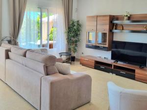 sala de estar con sofá y TV de pantalla plana en Apartamento en Playa la Arena, en Puerto de Santiago