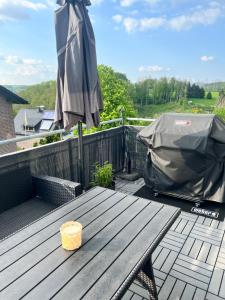 a patio table with an umbrella on a deck at Ferienvermietung Schneider in Wiehl