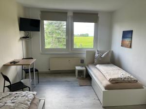 ein Wohnzimmer mit einem Sofa, einem Schreibtisch und einem Fenster in der Unterkunft Monteur-Pension N2 