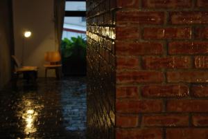 a brick wall next to a room with a chair at Howcome spots homestay in Hualien City