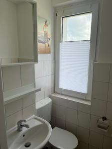 a bathroom with a sink and a toilet and a window at Monteur-Pension N2 