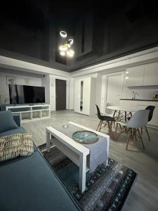 a living room with a couch and a table at Promenada Apartments in Năvodari +21 photos