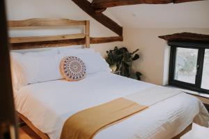 a bedroom with a white bed with a donut pillow on it at High House Barn in Bassenthwaite