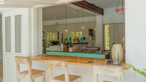 a kitchen with a counter with two chairs and a table at Villa Azulsalado - Frente a la playa in Las Terrenas