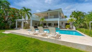 a house with chairs and a swimming pool at Villa Azulsalado - Frente a la playa in Las Terrenas