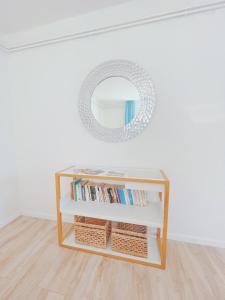 a shelf with books and a mirror in a room at StayHere Central City Studio 13 - contactless Self-Check-IN in Graz