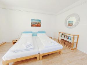 a white room with two beds and a book shelf at StayHere Central City Studio 13 - contactless Self-Check-IN in Graz