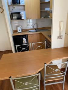 eine kleine Küche mit einem Holztisch und Stühlen in der Unterkunft Departamento Santiago Centro - Metro Santa Lucia in Santiago