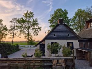 um pequeno edifício branco com um telhado preto em Bed en stal 'Het Woudhuisje' em Ryptsjerk
