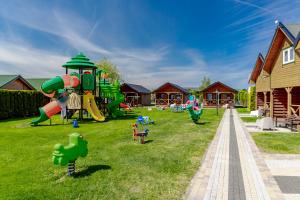 a playground with children playing on the grass at Domki Morena - Rodzinne Domki Blisko Plaży in Karwia +27 photos